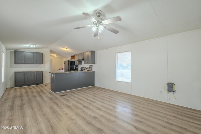 kitchen featuring stainless steel fridge, light wood-type flooring, and gray cabinets