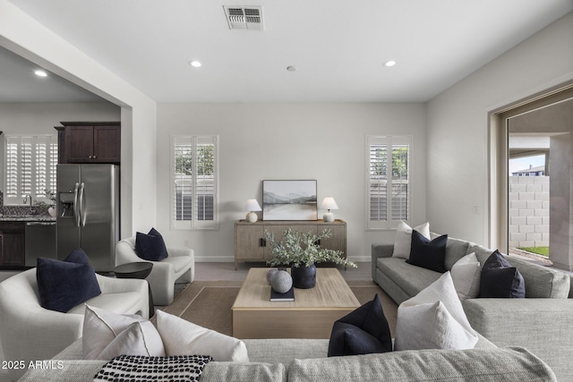 living room with recessed lighting, visible vents, and baseboards