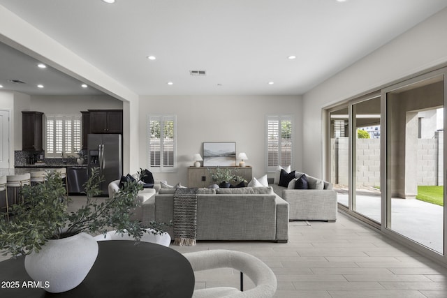 living area with recessed lighting, visible vents, and light wood-style flooring