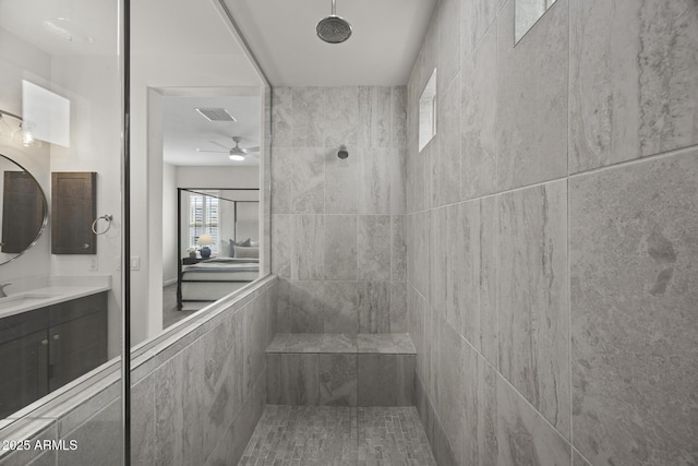 full bath with visible vents, tiled shower, and vanity