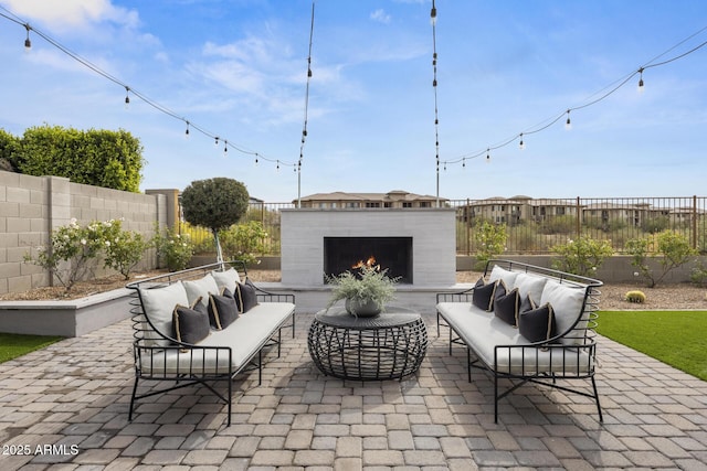 view of patio / terrace featuring a fenced backyard and an outdoor living space with a fireplace