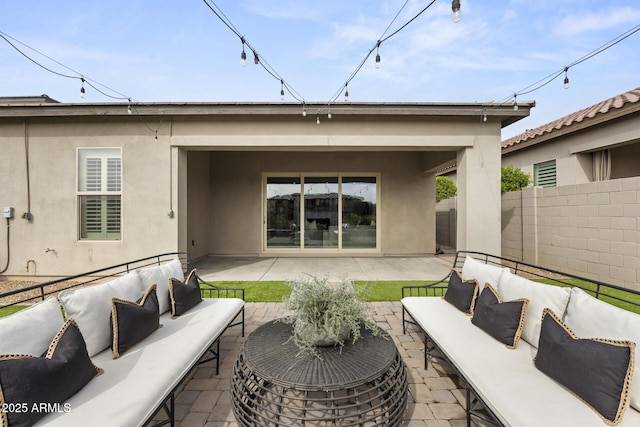 rear view of property with a patio area, fence, outdoor lounge area, and stucco siding