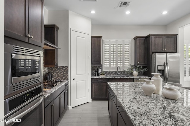 kitchen with appliances with stainless steel finishes, visible vents, and dark brown cabinetry