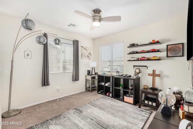 misc room featuring baseboards, carpet, visible vents, and a ceiling fan