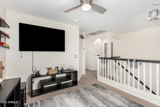 interior space featuring carpet floors, arched walkways, visible vents, and baseboards