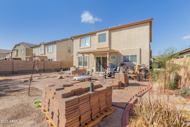 back of house with a fenced backyard, a patio, and stucco siding