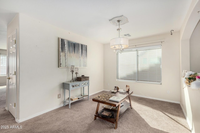 sitting room featuring a chandelier, carpet, and baseboards