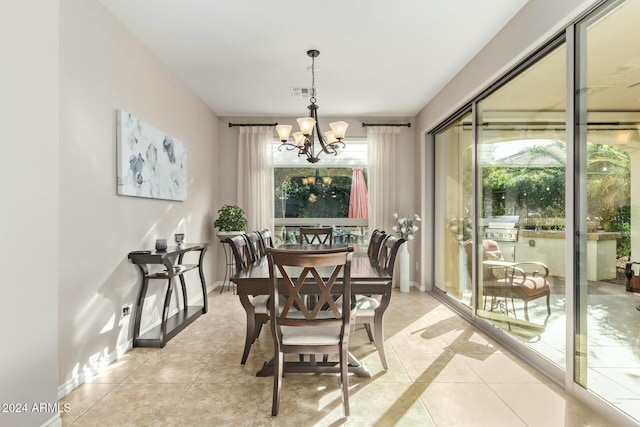 tiled dining room with an inviting chandelier