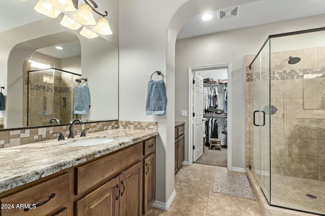 bathroom featuring tile patterned flooring, vanity, and a shower with door