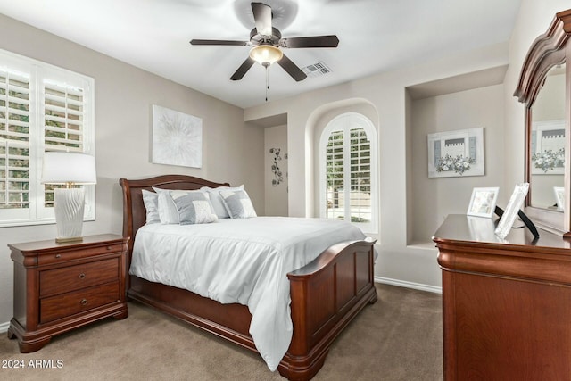 bedroom with ceiling fan, carpet floors, and multiple windows