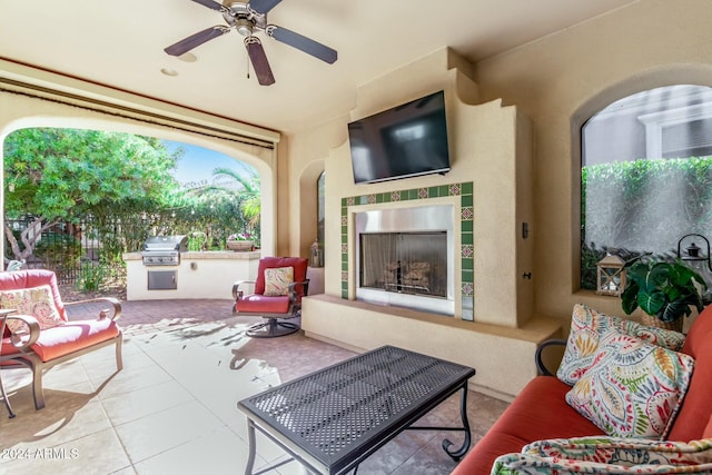 view of patio / terrace with ceiling fan, a grill, a fireplace, and an outdoor kitchen