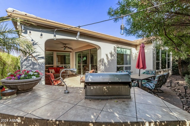 rear view of property with an outdoor living space, a patio, and ceiling fan