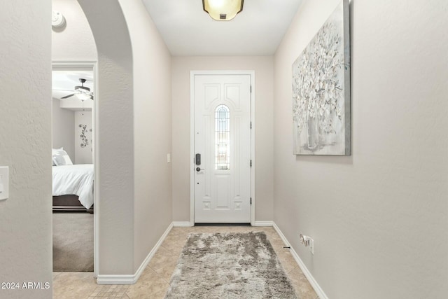 tiled foyer featuring ceiling fan