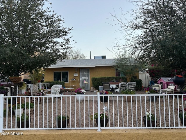 view of front facade featuring a patio, fence, and stucco siding