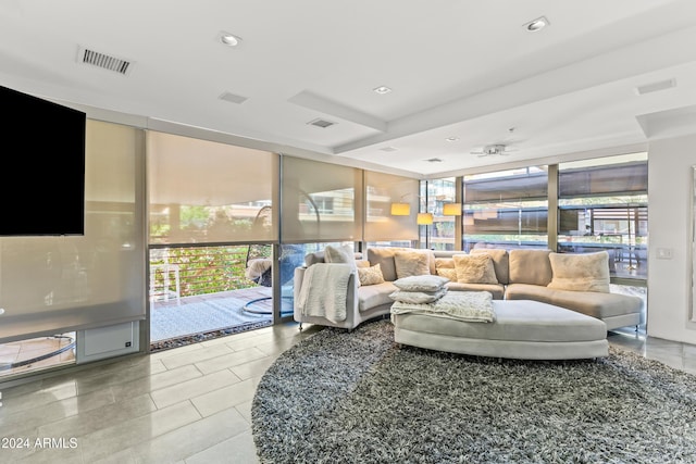 living room with ceiling fan and a wall of windows