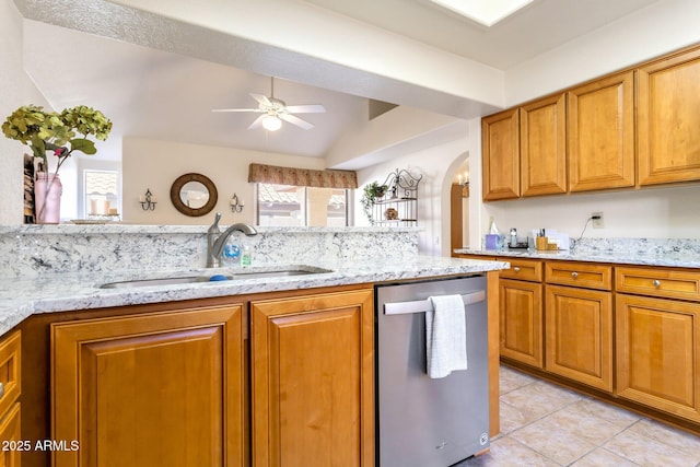 kitchen featuring light stone countertops, stainless steel dishwasher, sink, ceiling fan, and light tile patterned floors