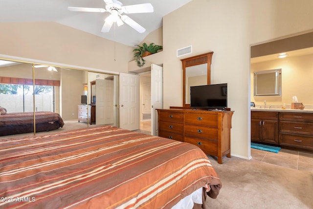 carpeted bedroom featuring vaulted ceiling, ceiling fan, sink, and ensuite bath