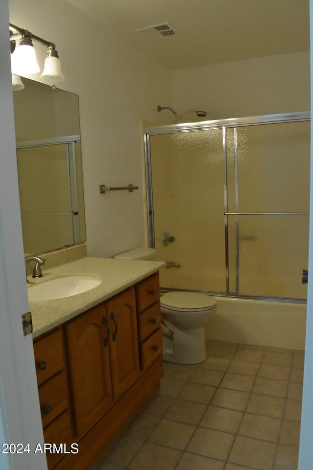 full bathroom featuring tile patterned floors, vanity, toilet, and combined bath / shower with glass door