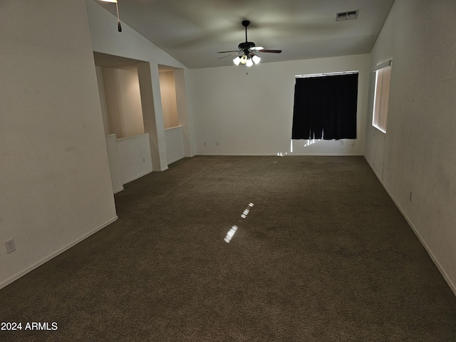 unfurnished room featuring dark colored carpet, vaulted ceiling, and ceiling fan