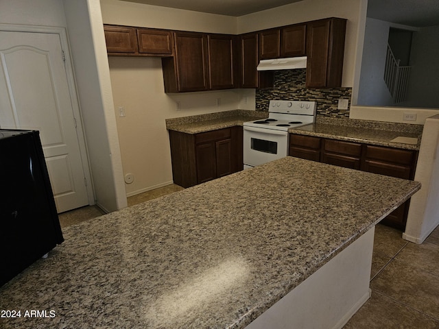 kitchen featuring white range with electric cooktop, dark brown cabinets, tile patterned floors, and tasteful backsplash