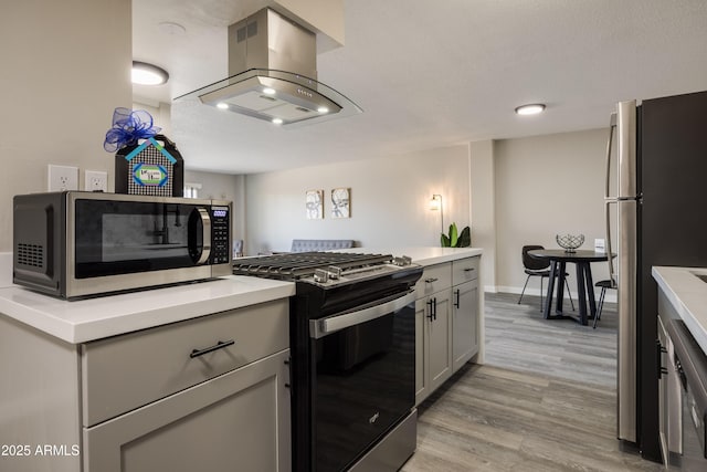 425 W Paseo Redondo Unit 6A, Tucson, AZ 85701 - kitchen featuring stainless steel appliances, island range hood, light wood-style floors, light countertops, and gray cabinets