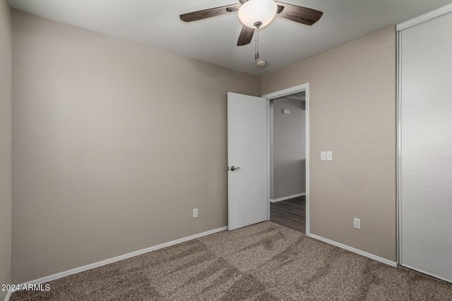 unfurnished bedroom with carpet, ceiling fan, and a closet