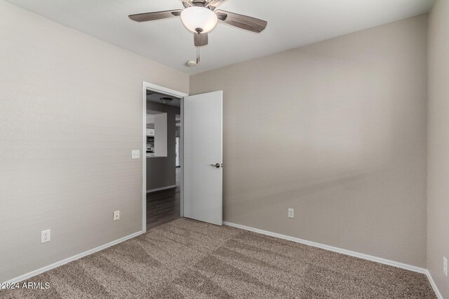 spare room featuring carpet floors, ceiling fan, and baseboards