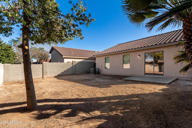 rear view of property with a patio, a fenced backyard, a tiled roof, cooling unit, and stucco siding