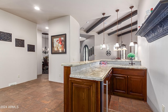 kitchen with light stone countertops, sink, beamed ceiling, kitchen peninsula, and pendant lighting