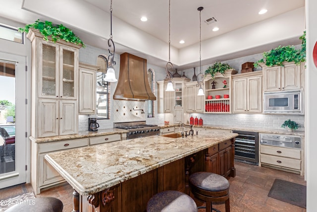 kitchen featuring wine cooler, decorative light fixtures, a kitchen bar, custom range hood, and stainless steel appliances