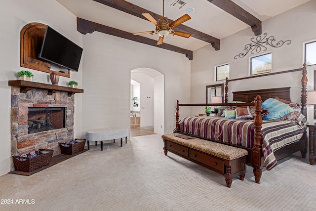 bedroom featuring connected bathroom, ceiling fan, beamed ceiling, a towering ceiling, and light colored carpet