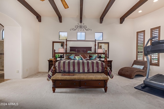 bedroom with beam ceiling and light carpet