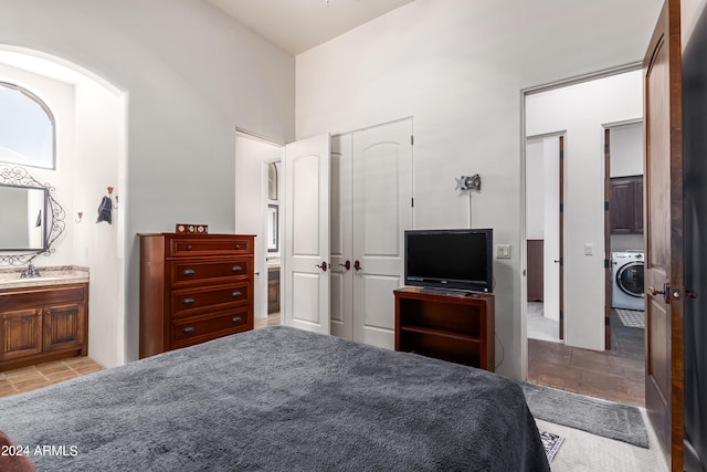 bedroom featuring washer / dryer, ensuite bathroom, and a closet