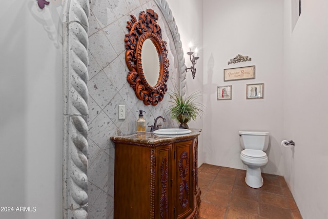 bathroom with vanity, tile walls, and toilet