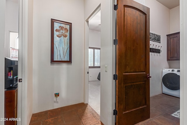 hall featuring washer / dryer and dark carpet