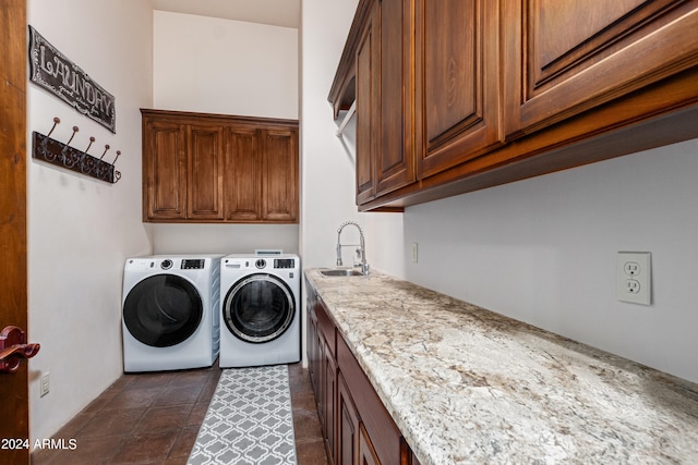 laundry area with cabinets, dark tile patterned floors, sink, and washing machine and clothes dryer