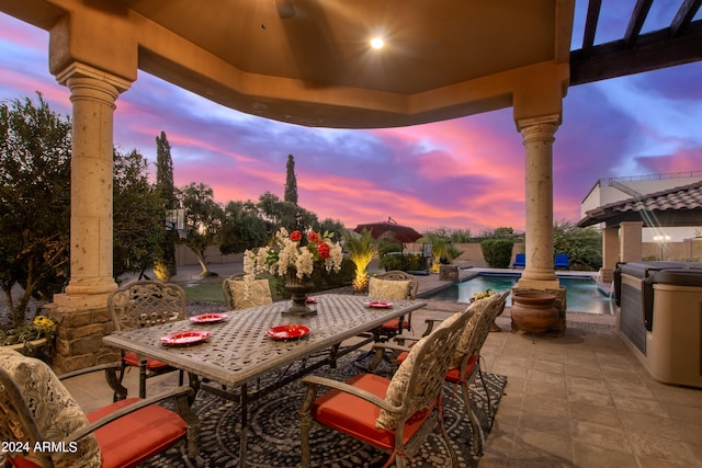 patio terrace at dusk featuring pool water feature