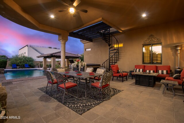 patio terrace at dusk with a gazebo and an outdoor living space with a fire pit