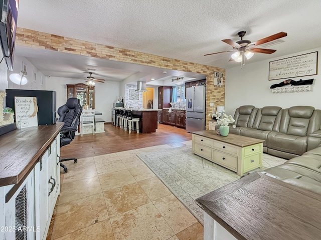 4639 W Keim Dr, Glendale, AZ 85301 - living room featuring a ceiling fan, a textured ceiling, light stone finish flooring, and an office area