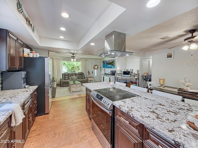 4639 W Keim Dr, Glendale, AZ 85301 - kitchen with a ceiling fan, stainless steel appliances, open floor plan, island exhaust hood, and light wood-style floors