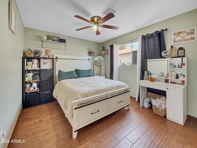 4639 W Keim Dr, Glendale, AZ 85301 - bedroom featuring light wood-style flooring, a textured ceiling, a ceiling fan, and baseboards