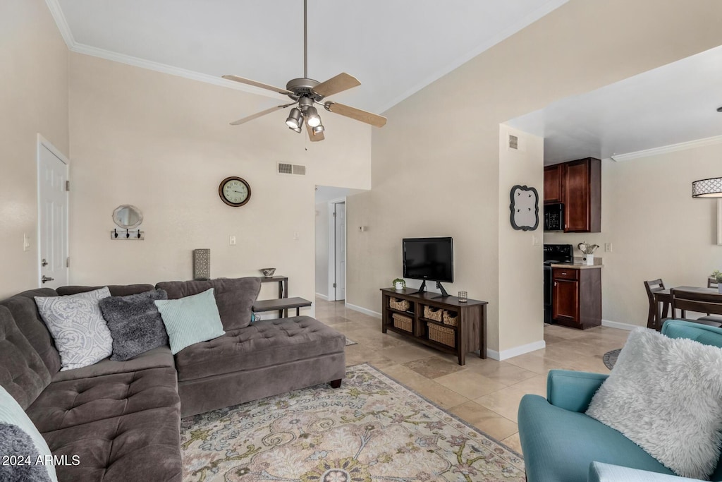 living room with a high ceiling, light tile patterned floors, ceiling fan, and ornamental molding