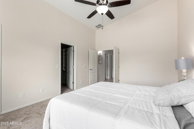 bedroom featuring visible vents, a walk in closet, baseboards, carpet floors, and high vaulted ceiling