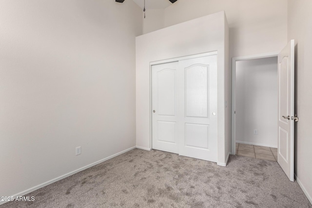 unfurnished bedroom with a closet, baseboards, and carpet floors