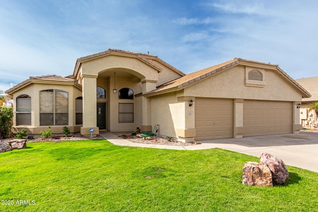 mediterranean / spanish-style house with stucco siding, driveway, a front yard, and a garage