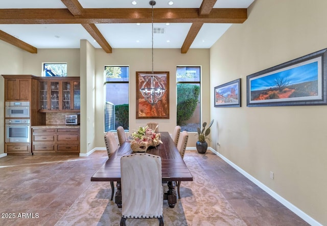 dining area featuring beam ceiling and a chandelier