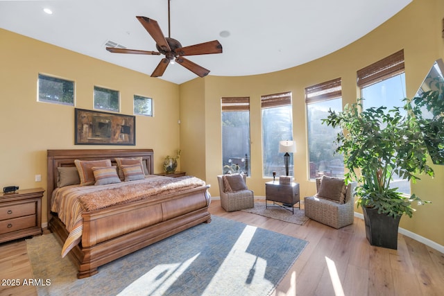 bedroom featuring multiple windows, light hardwood / wood-style flooring, and ceiling fan