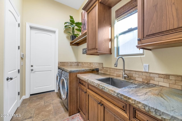 kitchen with stone countertops, separate washer and dryer, sink, and backsplash