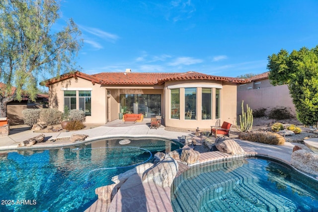 rear view of house featuring a fenced in pool and a patio