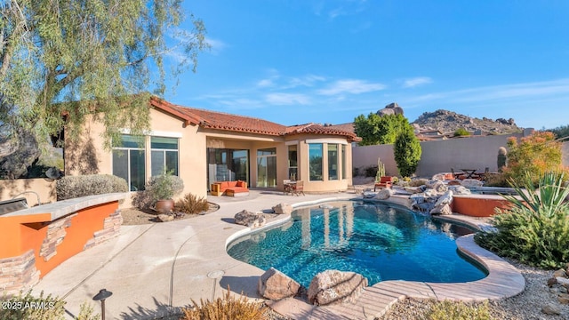 rear view of property with a jacuzzi and a patio